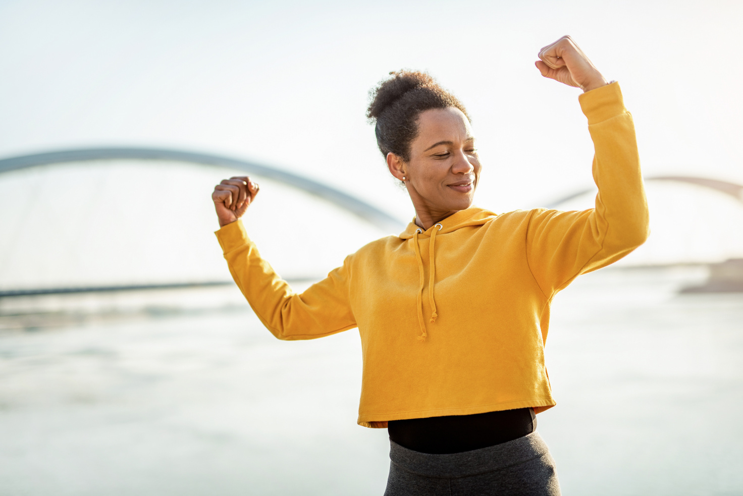 Happy strong woman flexing muscles.